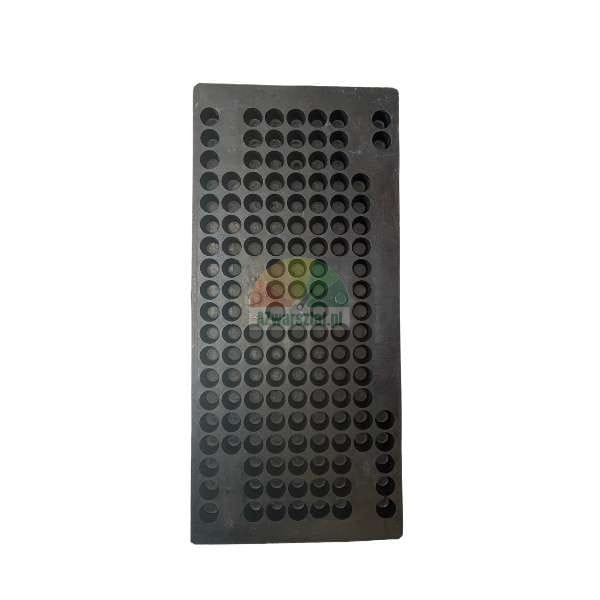 Dark rectangular plate with multiple circular holes or cavities, likely a capsule filling tray or mold.