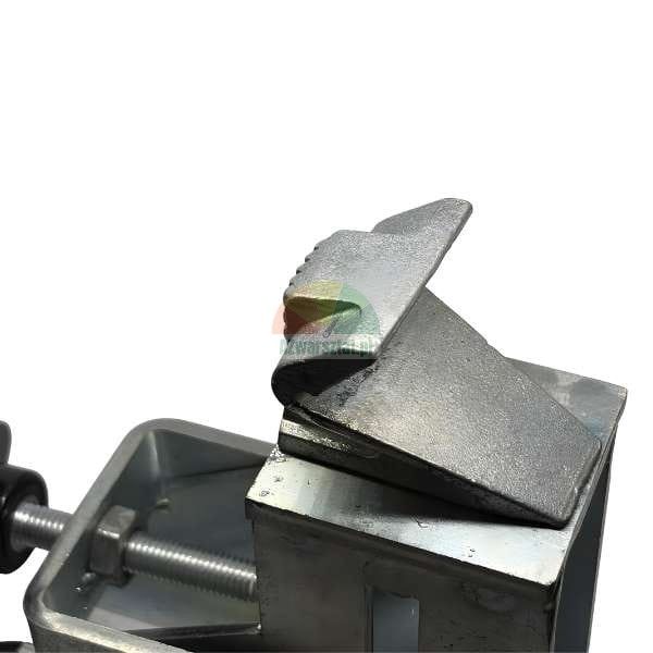 Close-up of metal angled clamping jaws or vise components showing serrated wedge-shaped inserts