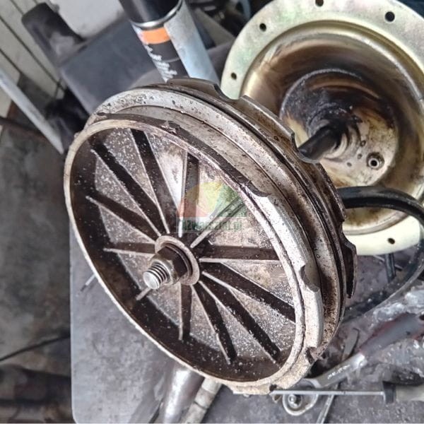 Dirty metal mechanical part with ribs and a nut in the center