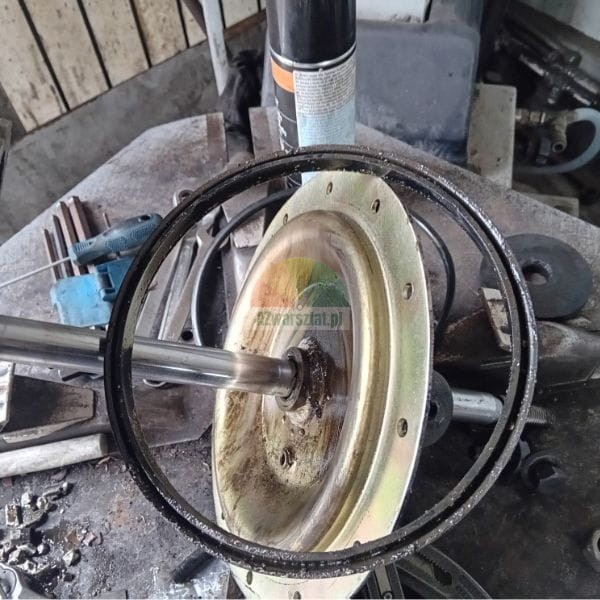 Metal motor hub and sealing ring on a workbench surrounded by tools.