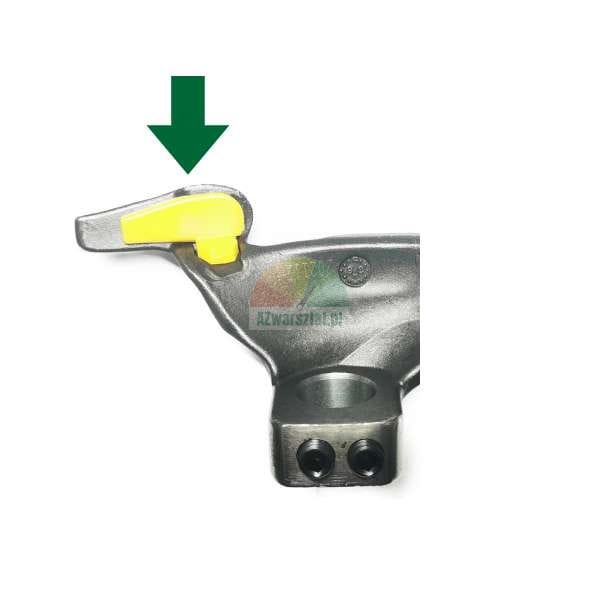 Metal mounting head of a tire changer with a green arrow pointing to a yellow plastic protective insert.