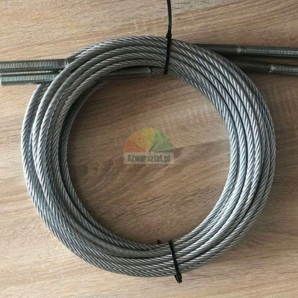 Coiled steel wire rope with threaded stud ends fastened by black cable ties on a wood background.