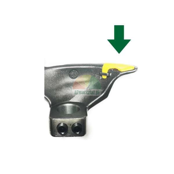 Metal machine arm with a yellow protective element indicated by a green arrow.