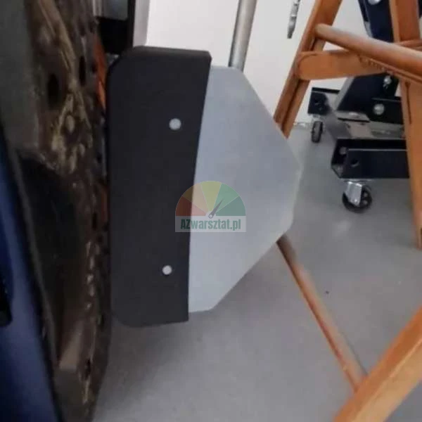 Black bumper with a metal plate mounted on a mechanical structure in a workshop