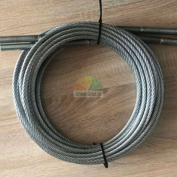 Coiled steel wire rope with threaded ends on a wooden surface