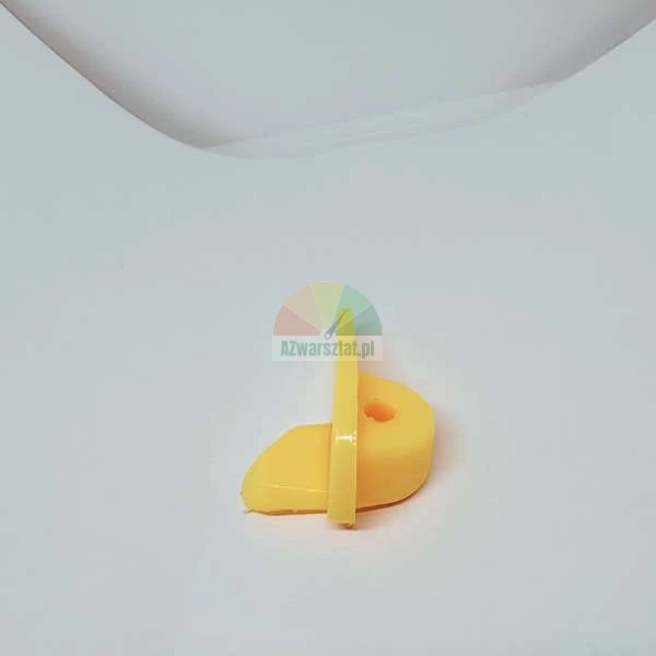 Small yellow plastic component with a hole on a white background