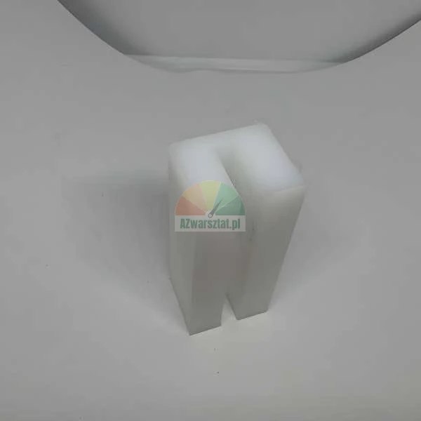 White U-shaped plastic spacer block standing on a white surface.