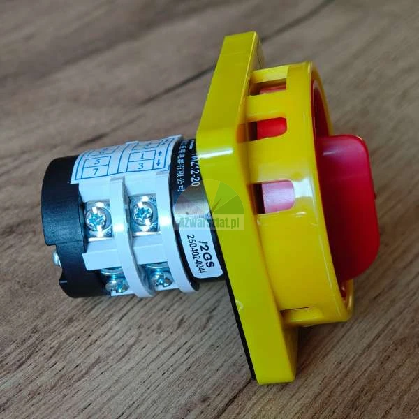 Industrial rotary isolator switch with a red handle and yellow housing showing electrical terminals.