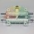 White plastic pneumatic manifold with metal rods and a brass fitting on a light background.