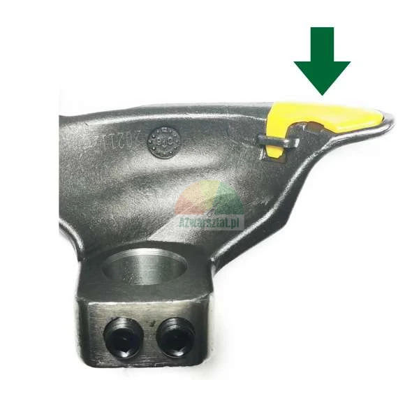 Close-up of a metal tire changer mounting head with a yellow plastic protector indicated by a green arrow.