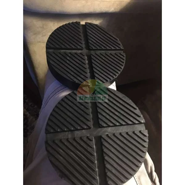 Two black rubber jack pads with cross-slotted surface patterns