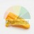 Yellow plastic replacement part, latch or button for a household appliance on a white background.