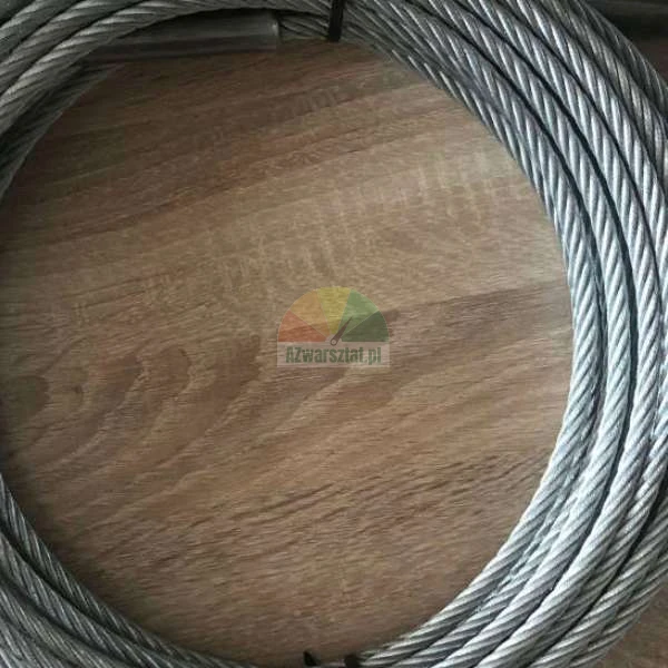 Coiled steel wire rope lying on a wooden surface