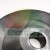 Close-up of a machined round metal part with a central hole on a bright background.