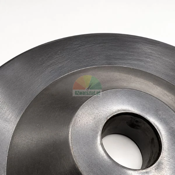 Close-up of a machined round metal part with a central hole on a bright background.