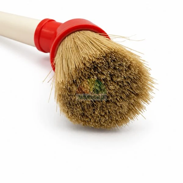 Close-up of a round washing brush head with natural bristles, red plastic collar and light handle